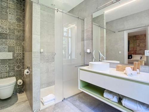 a bathroom with a sink and a toilet and a mirror at Les Begards Espace 9 in Chaudfontaine