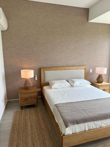 a bedroom with a bed and two lamps on tables at Nuevo Apartamento Campestre in El Caimo