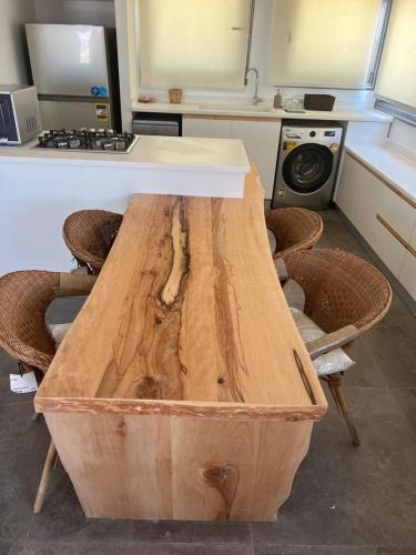 a wooden table in a kitchen with a counter at Caesar Sodic in Ras Elhekma