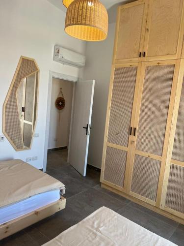 a bedroom with a large wooden cabinet and a mirror at Caesar Sodic in Ras Elhekma