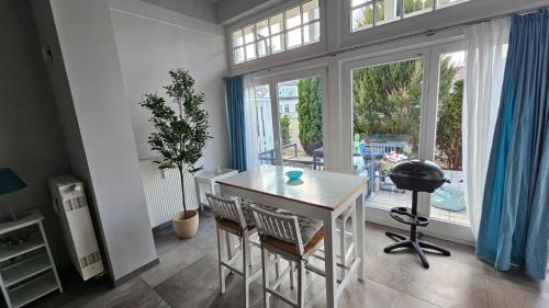 a room with a table and chairs and a large window at Ferienwohnung Kühlungsborn - Strand, Park und Wald in Kühlungsborn