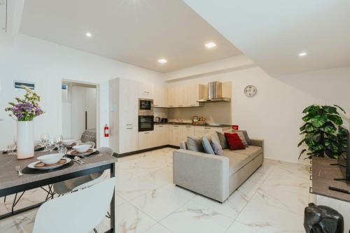 a living room with a couch and a kitchen at Luma apartment - Sliema with Outdoor Space and BBQ Area in Sliema