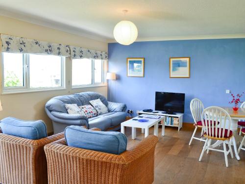 a living room with a couch and a tv at Treyarnon in St Merryn
