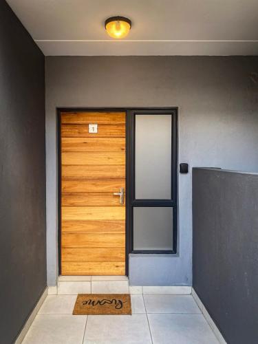 a wooden door in a room with a mat in front at The Grey Oasis in Tzaneen