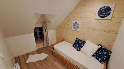 Cette petite chambre mansardée comprend un lit. dans l'établissement Gite du B-ffroy - Besse et St Ansataise, à Besse-et-Saint-Anastaise