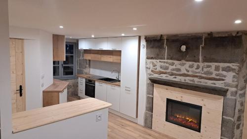 une cuisine avec une cheminée au milieu dans l'établissement Gite du B-ffroy - Besse et St Ansataise, à Besse-et-Saint-Anastaise