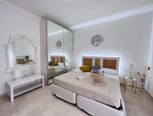 a white bedroom with a bed and a mirror at Stella dei Venti B&B in San Salvo