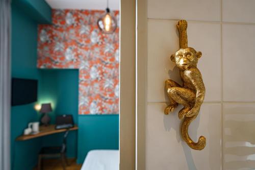 a room with a monkey hanging on the wall at The Originals Boutique, Hôtel Le Londres, Saumur in Saumur