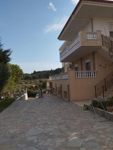 a house with a stone driveway next to a building at Apartment Irini 1 in Ayios Nikolaos Sithonia