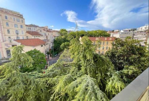 un groupe d'arbres au sommet d'une ville dans l'établissement L'ILOT avec balcon, mignon et charmant, un havre de paix au cœur du centre-ville, à Cannes