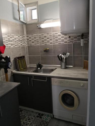 une cuisine avec une machine à laver et un évier dans l'établissement joli sudio clim centre ville, à Avignon