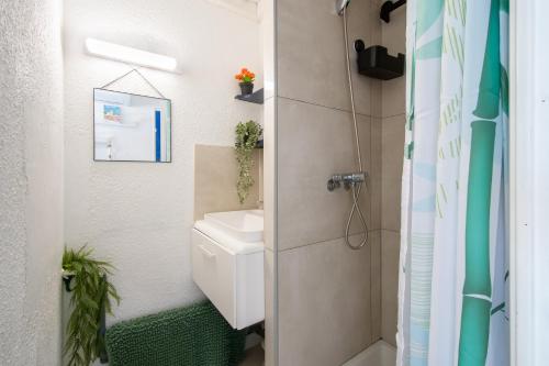 une petite salle de bain avec toilettes et douche dans l'établissement Studio cabine cosy Lagon Bleu Piscine, clim, parking, wifi inclus, au Grau-du-Roi