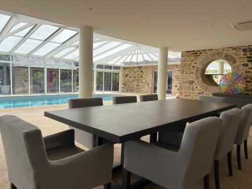 une salle à manger avec une table et des chaises noires dans l'établissement Grande maison en campagne avec piscine, 11 voyageurs, à Hénansal