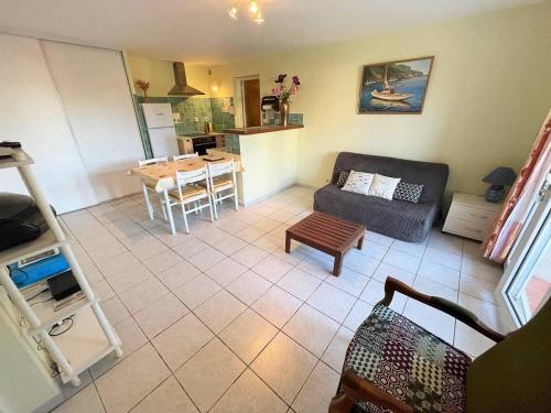 un salon avec un canapé et une table dans l'établissement Bas de villa proche de toute commodités, à Saint-Mandrier-sur-Mer