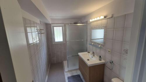 une salle de bain blanche avec un lavabo et une douche dans l'établissement Bas de villa proche de toute commodités, à Saint-Mandrier-sur-Mer