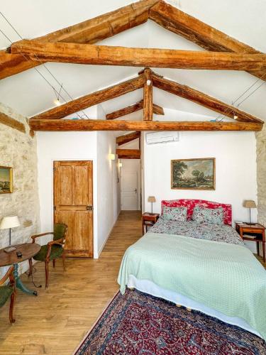 - une chambre avec un grand lit et des poutres apparentes dans l'établissement Le Clos Des Chartreux, à Villeneuve-lès-Avignon