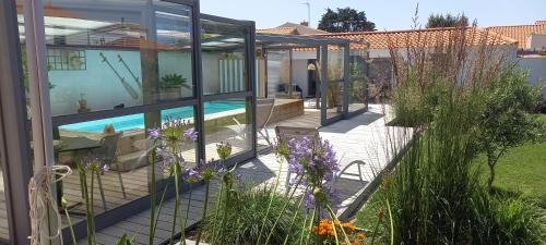 une maison avec une piscine dans un jardin dans l'établissement Villa des Huniers à La Chaume, à La Chaume