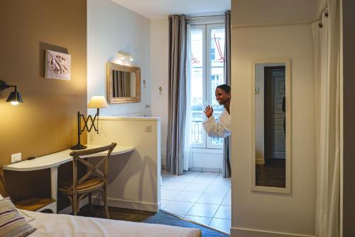a man taking a picture of a hotel room at The Originals Boutique, Hôtel Le Londres, Saumur in Saumur