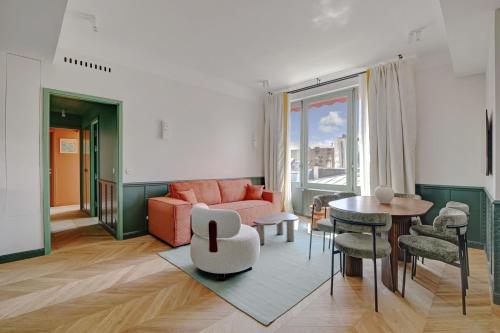 un salon avec un canapé et une table dans l'établissement Paris Home Collection Serviced Apartments in Opéra - Rue Saint-Lazare, à Paris