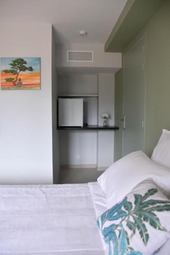 - une chambre dotée d'un lit blanc avec une photo sur le mur dans l'établissement La Fourmy Verte, à Taradeau