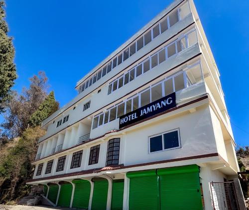 a hotel with green doors in front of a building at Hotel Jamyang in Bomdila