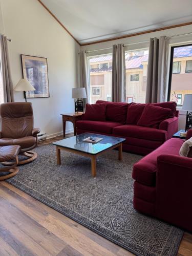 a living room with a red couch and a coffee table at Pet Friendly Condo near Loon with Loon Club passes in Lincoln