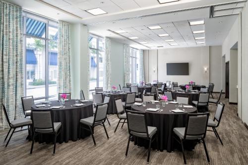 a conference room with tables and chairs and a screen at Hyatt Place West Palm Beach in West Palm Beach