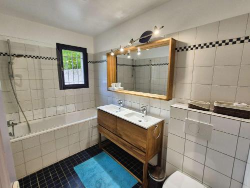 une salle de bain avec un lavabo, une baignoire et un miroir dans l'établissement Piscine, plage à pied, WIFI, billard, babyfoot, ping pong, BBQ..., à La Seyne-sur-Mer