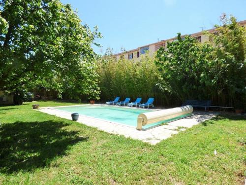 une piscine avec deux chaises et un toboggan dans une cour dans l'établissement Piscine, plage à pied, WIFI, billard, babyfoot, ping pong, BBQ..., à La Seyne-sur-Mer