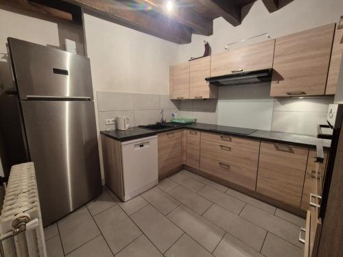 une cuisine avec un réfrigérateur et des armoires en acier inoxydable dans l'établissement CHALET CROUZE - Chaleureux Chalet, ski au pied - 14 personnes, à Tignes