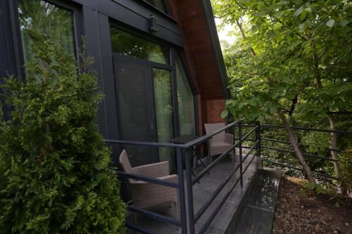 a screened porch of a house with two chairs at Chalet by Provence Suceava in Suceava