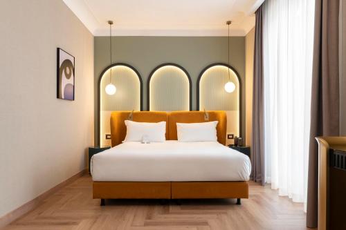 a bedroom with a large bed with white sheets at Je Rome Hotel in Rome