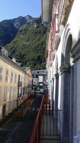 une rue urbaine avec des bâtiments et une montagne en arrière-plan dans l'établissement Appartement 3Etoiles Plein centre ville Cauterets avec balcon, à Cauterets