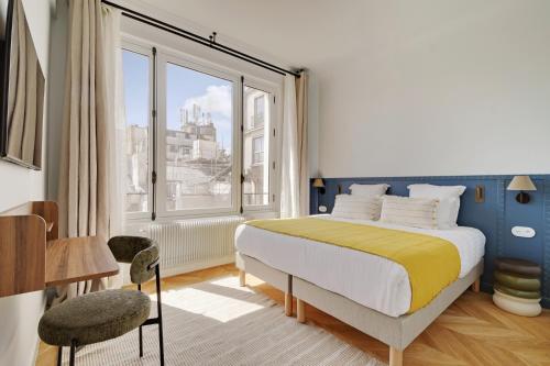 une chambre avec un lit et une grande fenêtre dans l'établissement Paris Home Collection Serviced Apartments in Opéra - Rue Saint-Lazare, à Paris
