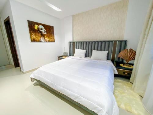 una camera da letto bianca con un grande letto bianco di Residence le reve a Dakar
