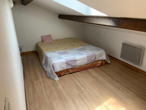 une petite chambre avec un lit dans un grenier dans l'établissement Maison E piscine vélodrome, à Marseille