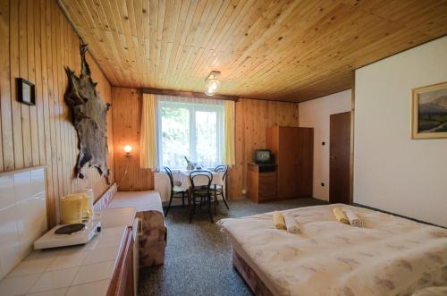 a bedroom with two beds and a table in it at Penzion Ivana in Harrachov