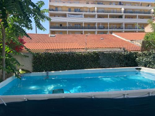 une grande piscine bleue devant un immeuble dans l'établissement Maison E piscine vélodrome, à Marseille