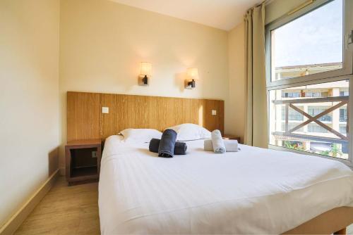 - une chambre avec un grand lit blanc et une grande fenêtre dans l'établissement Le Cannes Beach 447 - Confort & soleil - Piscine, à Cannes