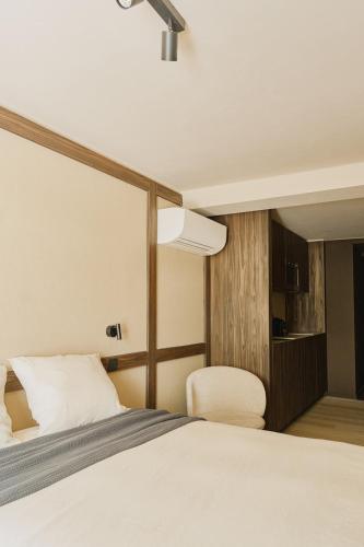 a bedroom with a large bed and a chair at Raibu Ghent by StayC in Ghent