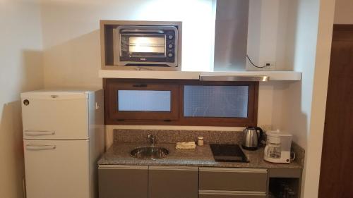 a small kitchen with a sink and a microwave at Álamos de los Andes - Andarlibre in San Martín de los Andes