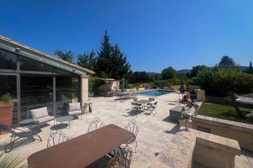 un patio avec tables et chaises et une piscine dans l'établissement La Belle de Lagnes, à Lagnes
