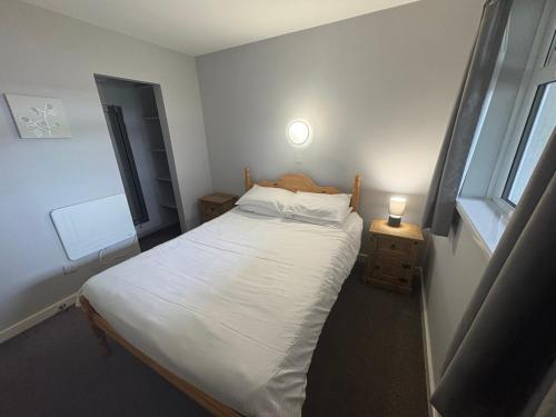 mała sypialnia z łóżkiem i oknem w obiekcie Rathlin Apartment - 2 Bedroom with Hot Tub w mieście Ballycastle