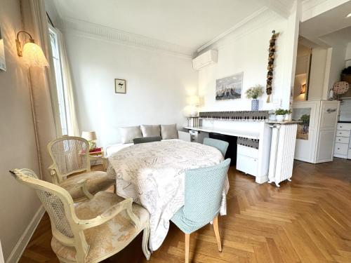 une chambre blanche avec une table et un piano dans l'établissement BB G Balcon Excelsior 3 - Grimaldi, à Nice