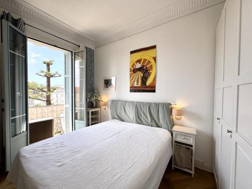 une chambre avec un lit blanc et une fenêtre dans l'établissement BB G Balcon Excelsior 3 - Grimaldi, à Nice