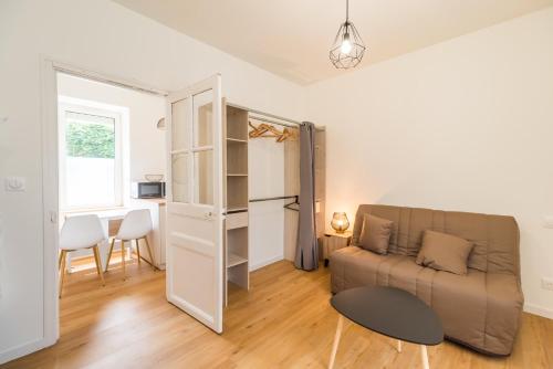 un salon avec un canapé et une table dans l'établissement Studio pratique & cosy - centre de Guingamp, à Guingamp