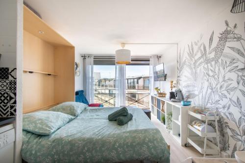 une chambre avec un lit et une grande fenêtre dans l'établissement Studio cabine cosy Lagon Bleu Piscine, clim, parking, wifi inclus, au Grau-du-Roi