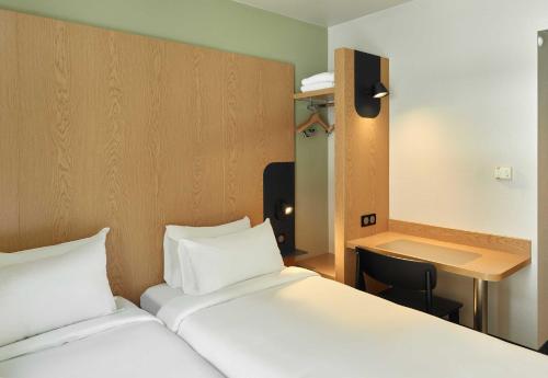 a hotel room with two beds and a desk at B&B HOTEL Paris Est Bobigny Université in Bobigny
