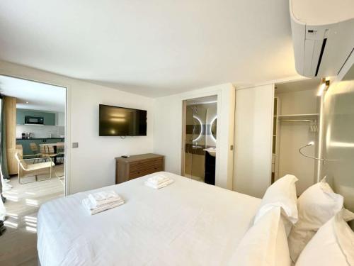 une chambre avec un lit blanc et un miroir dans l'établissement PARISIAN HOME l MONTMARTRE, à Paris