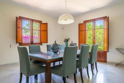 a dining room with a wooden table and green chairs at Il Giardino di Venere in Mondello